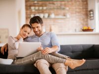 Close up of a happy young couple using laptop at home